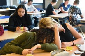 Twee vermoeide leerlingen in een middelbare schoolklas. Beeld Marcel van den Bergh