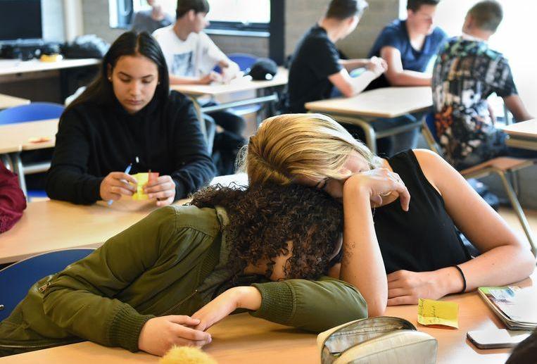 Twee vermoeide leerlingen in een middelbare schoolklas. Beeld Marcel van den Bergh